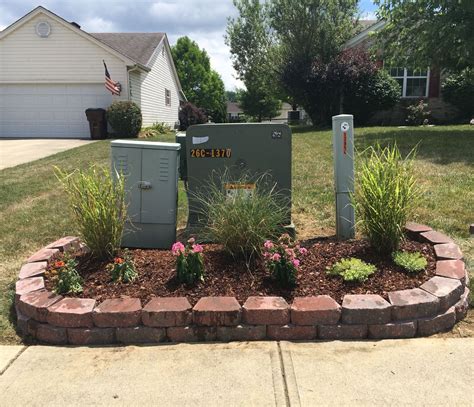 green electrical boxes in yard|landscape around electrical transformer boxes.